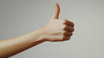 A hand giving a thumbs-up gesture against a white background photo