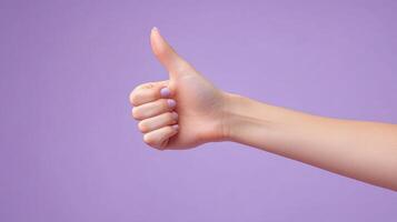 Close-up of a Hand Giving a Thumbs-Up Gesture on a Lavender Background photo
