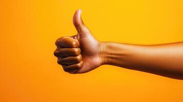 A Hand Gesturing Thumbs Up Against a Bright Yellow Background photo