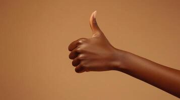 Close-up of a Brown Hand Giving a Thumbs Up Gesture photo
