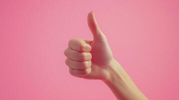 A Hand Giving a Thumbs Up Gesture Against a Pink Background photo