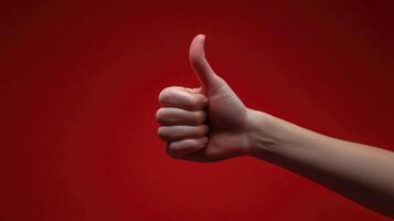 A Hand Giving a Thumbs Up Gesture Against a Red Background photo