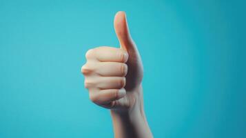 A Hand Giving a Thumbs Up Gesture Against a Blue Background photo