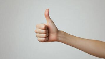 A hand with a thumb extended upward in a thumbs-up gesture. photo