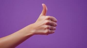 A Hand Gesturing Thumbs Up Against a Purple Background photo