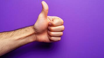 A Hand Giving a Thumbs Up Gesture Against a Purple Background photo