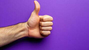 A Hand Giving a Thumbs Up Gesture Against a Purple Background photo