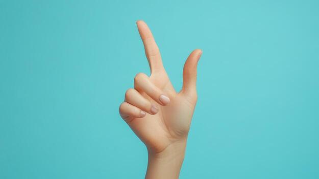 A single hand extended with the index finger pointing upwards against a turquoise background photo