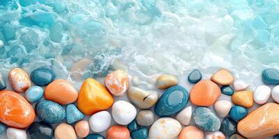 Smooth, colorful stones against a turquoise water background photo
