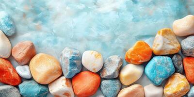 Smooth, Colorful Pebbles Arranged on a Light Blue Background photo