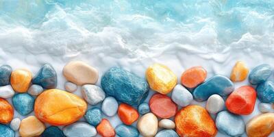 Colorful Smooth Stones on a White Sandy Beach with Ocean Water in the Background photo