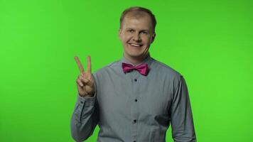 Man showing victory sign, success and win, peace gesture and smiling with kind optimistic expression video
