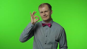 Man showing ok gesture, smiling with optimistic satisfied expression, winking, okay sign of approval video