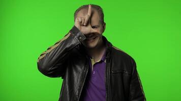 Man showing loser gesture, pointing finger to camera, sarcastic smile, blaming for failure, lost job video