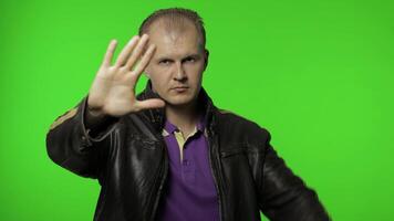 Rocker man showing stop gesture with hands. No, never, disliking and rejecting sign. Chroma key video
