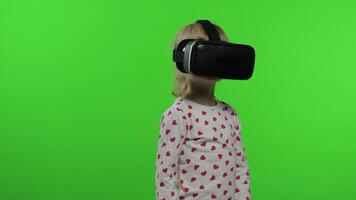 Child girl using VR headset helmet to play game. Watching virtual reality 3d 360 . Chroma key video