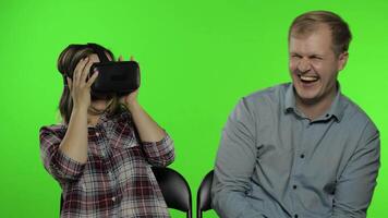 Man and woman using VR headset helmet to play game. Watching virtual reality 3D . Chroma key video