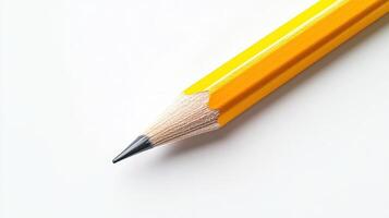 A close-up of a sharpened yellow pencil on a white surface photo