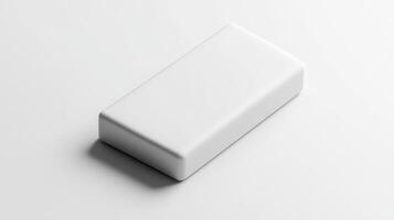Plain white eraser resting on a smooth surface in a well-lit environment photo