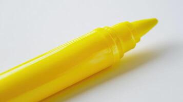 Yellow highlighter pen resting on a clean white surface during the day photo