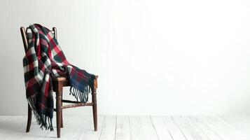 A cozy plaid blanket draped over a rustic wooden chair in a simple interior space photo