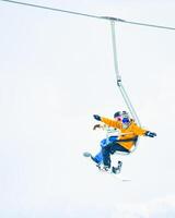 Gudauri, Georgia - 15th february, 2024 - two friends in ski lift pose go up isolated in white snowy background mock up photo