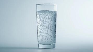 Sparkling water in a clear glass on a light background photo