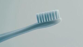 Close-up of a soft-bristled toothbrush against a light gray background, perfect for dental hygiene routines photo