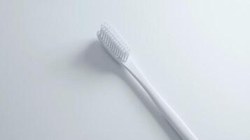 A close-up view of a white toothbrush on a clean, minimalistic surface photo