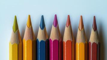 Colorful pencils arranged in a straight line on a light background for artistic creativity photo