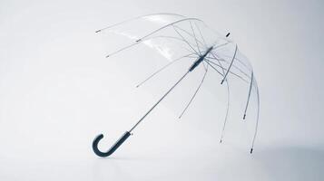 A clear umbrella stands upright on a plain surface with a minimalist background photo