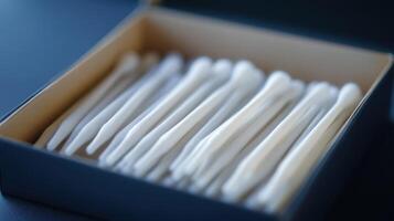 A neatly arranged box of cotton swabs placed on a simple table photo