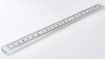 Clear plastic ruler lying on a white surface with measuring markings along its length photo