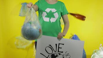 irreconhecível mulher com protestando poster e terra globo dentro plástico pacote. ecologia poluição video