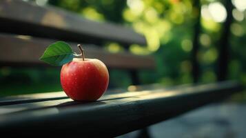 A Bright Red Apple Resting on a Weathered Bench in a Tranquil Park During Late Afternoon Light photo