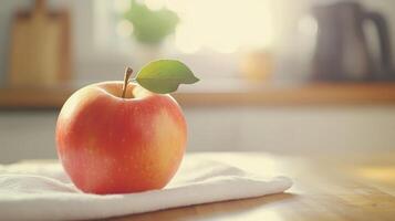 Fresh Red Apple With Leaf Resting On White Cloth In Bright Kitchen During Morning Light photo