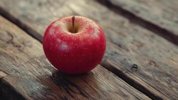 Fresh Red Apple Resting on Rustic Wooden Table in Natural Light photo