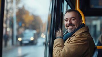 Happy Man Smiling While Leaning Out of City Bus Window During Autumn Afternoon in Urban Setting photo