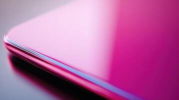 Close-Up View of Sleek Pink Smartphone on a Reflective Surface at Daytime photo