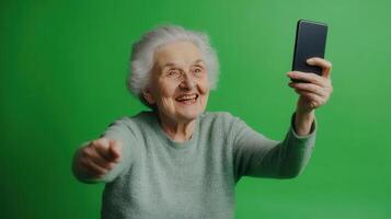 Elderly woman smiling and taking a selfie against a vibrant green backdrop photo
