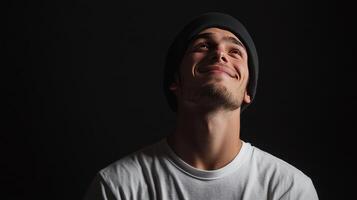 Young man smiling and looking upward in a dark setting reflecting a moment of joy or contemplation photo