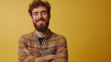 Smiling young man with curly hair crossed arms against a vibrant yellow background in a casual setting photo