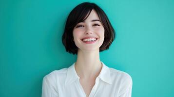 Young woman smiling in front of a teal wall during daylight hours photo