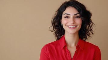 Young woman smiling in a red shirt against a neutral background photo
