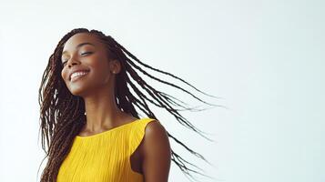 Young woman with braids smiles while wearing a yellow dress against a light background photo