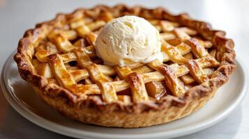 Freshly baked apple pie topped with a scoop of vanilla ice cream on a white plate photo