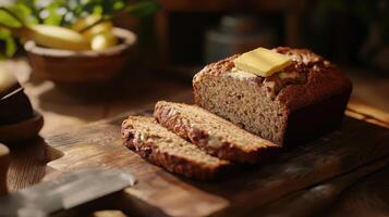 Freshly baked banana bread on a wooden board with slices and a pat of butter, surrounded by natural light and rustic decor photo