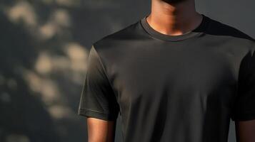 A person wearing a black t-shirt standing against a textured wall during the late afternoon photo