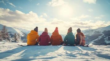 Group of friends enjoying a winter day on a snowy mountain, admiring the sun shining through the clouds in the afternoon photo