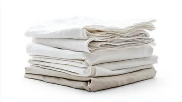 Neatly folded linens in various shades of white and beige on a clean surface photo